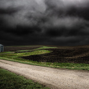 Grain Bins in the middle of an open field against a dark sky