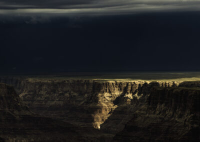 Storm over the eastern edge of the Grand Canyon while a piecing light strikes the confluence of the Little Colorado and the Colorado Rivers