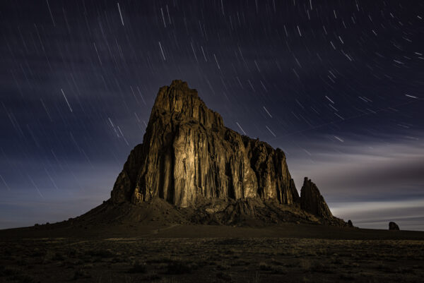 Shiprock lit up by the moon during a 20 min exposure for star trails