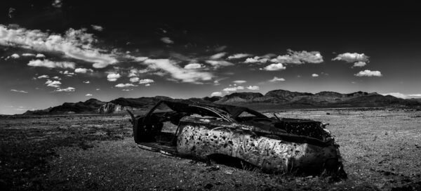 Classic car with bullet holes in the middle of the desert