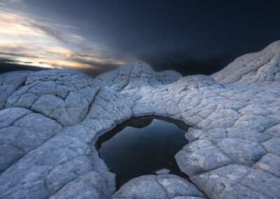 Small rain filled pool reflecting the blue hour blue sky at the White Pocket